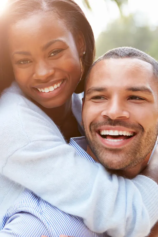 Erectile-Dysfunction-Treatment A woman riding on a man's back, both smiling due to help with erectile dysfunction from Optimal Wellness Medical Group in Grand Rapids.
