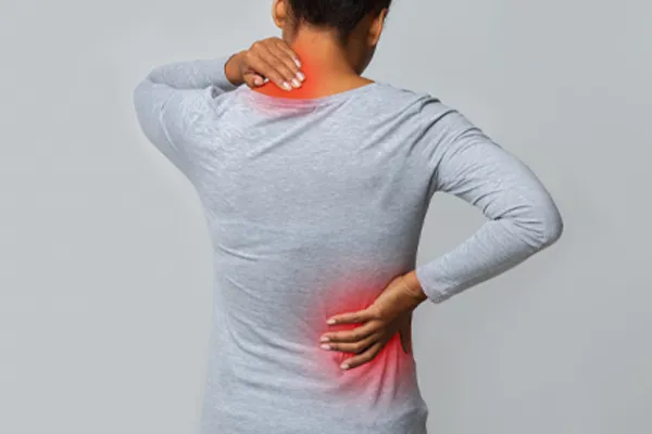 Fibromyalgia-Clinic An image from behind of a woman suffering from Fibromyalgia holding her hands on her neck and lower back. Get fibromyalgia care from Optimal Wellness Medical Group in Grand Rapids.