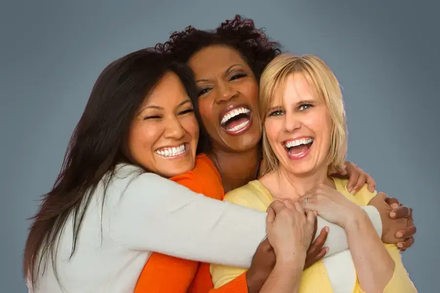 Insulin-Resistance-Clinic An asian, black, and white woman of middle age hug and laugh. Get insulin resistance treatment from Optimal Wellness Medical Group in Grand Rapids.