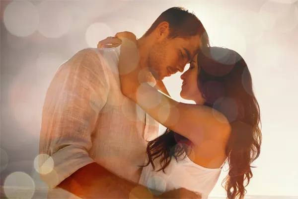 Sexual-Wellness-for-Women-and-Men-Doctor A couple in linen shirts standing in a sparkling light embraces each other with their foreheads touching and eyes closed, happy with their sexual wellness treatments from Optimal Wellness Medical Group in Grand Rapids.