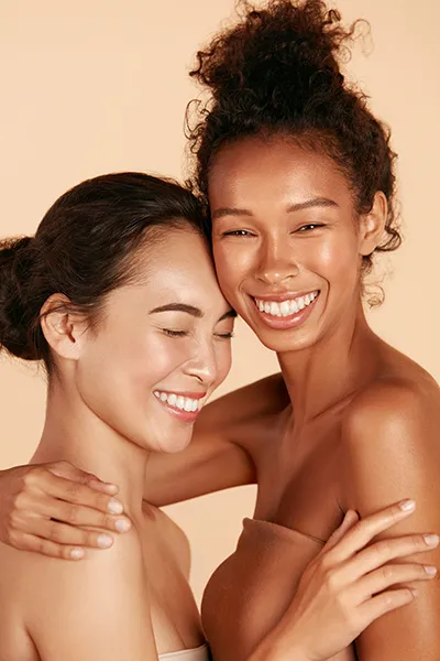 Two beautiful, radiant women with glowing skin. Receive SWiCH Dermal Rejuvenation treatment by Optimal Wellness Medical Group in Grand Rapids.